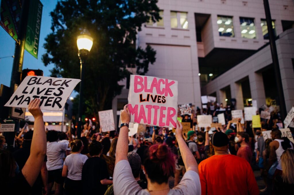 A vibrant Black Lives Matter protest with signs and a diverse crowd in an urban setting.