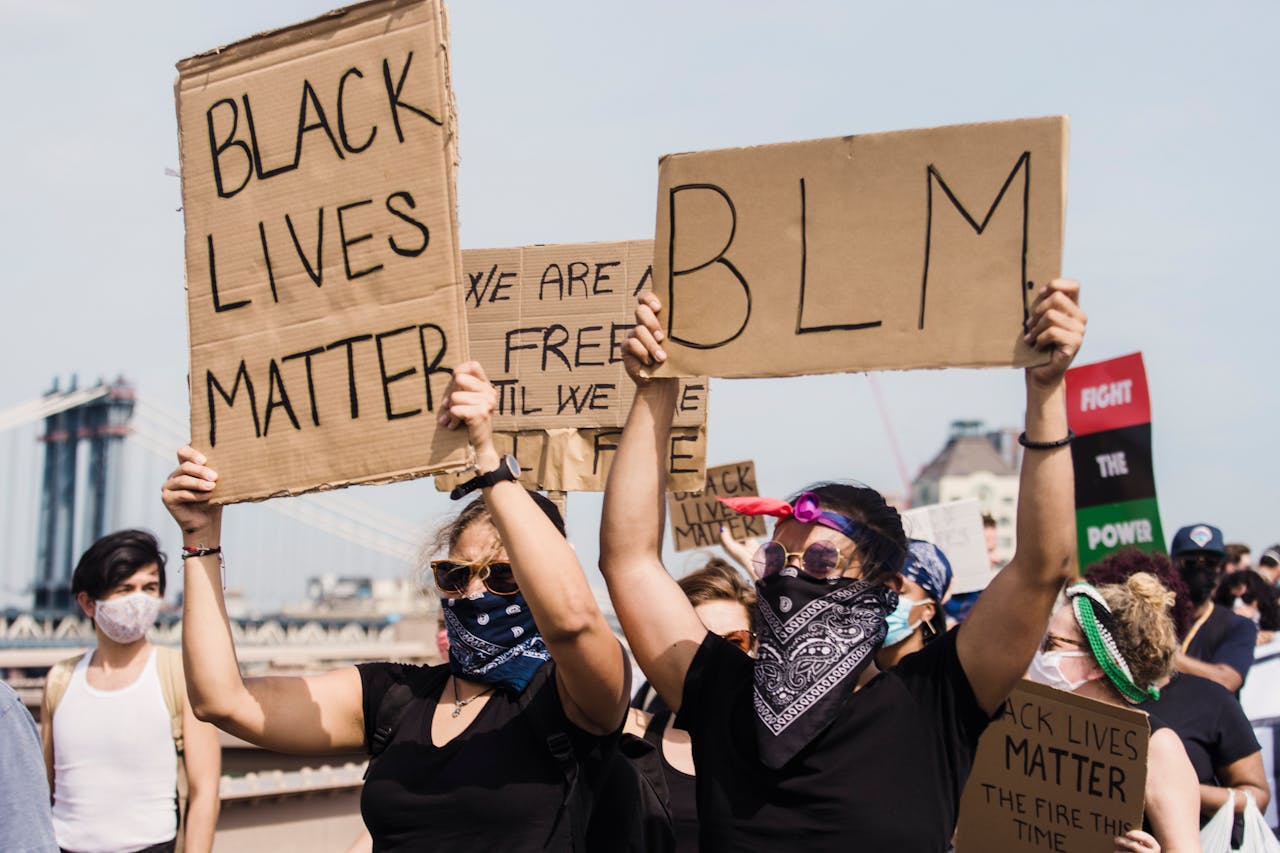 Protestors holding signs at a Black Lives Matter demonstration advocating for justice and equality.